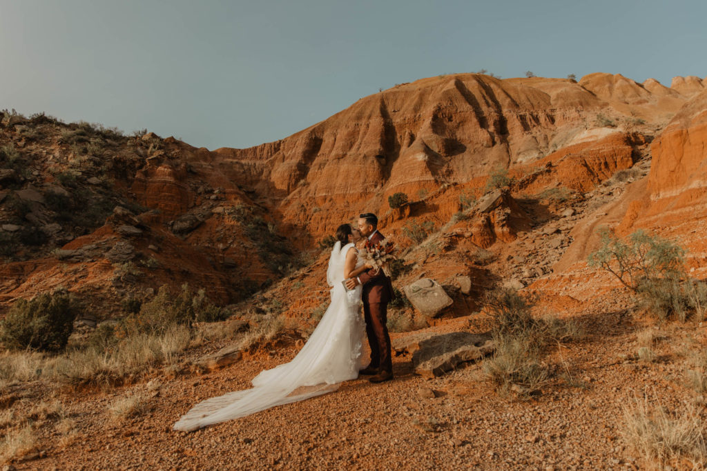 Palo Duro Canyon. Couple gets ready to exchange vows to each other on red rock. first kiss elopement 