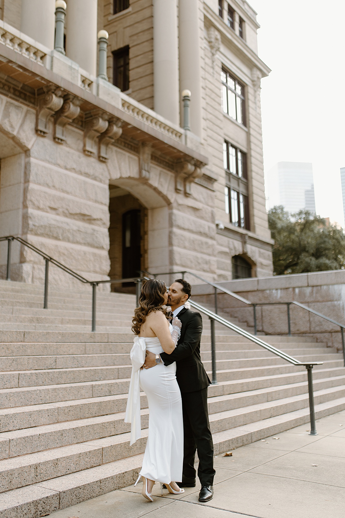 man and women kissing outside 1910 Courthouse after their elopement ceremony