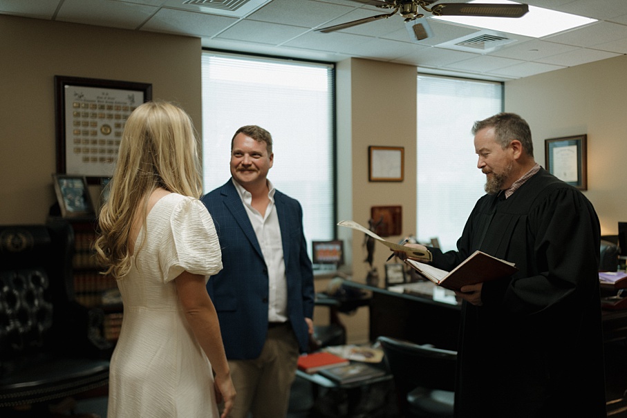 Candid moment of an engaged couple smiling inside the Conroe Courthouse.
